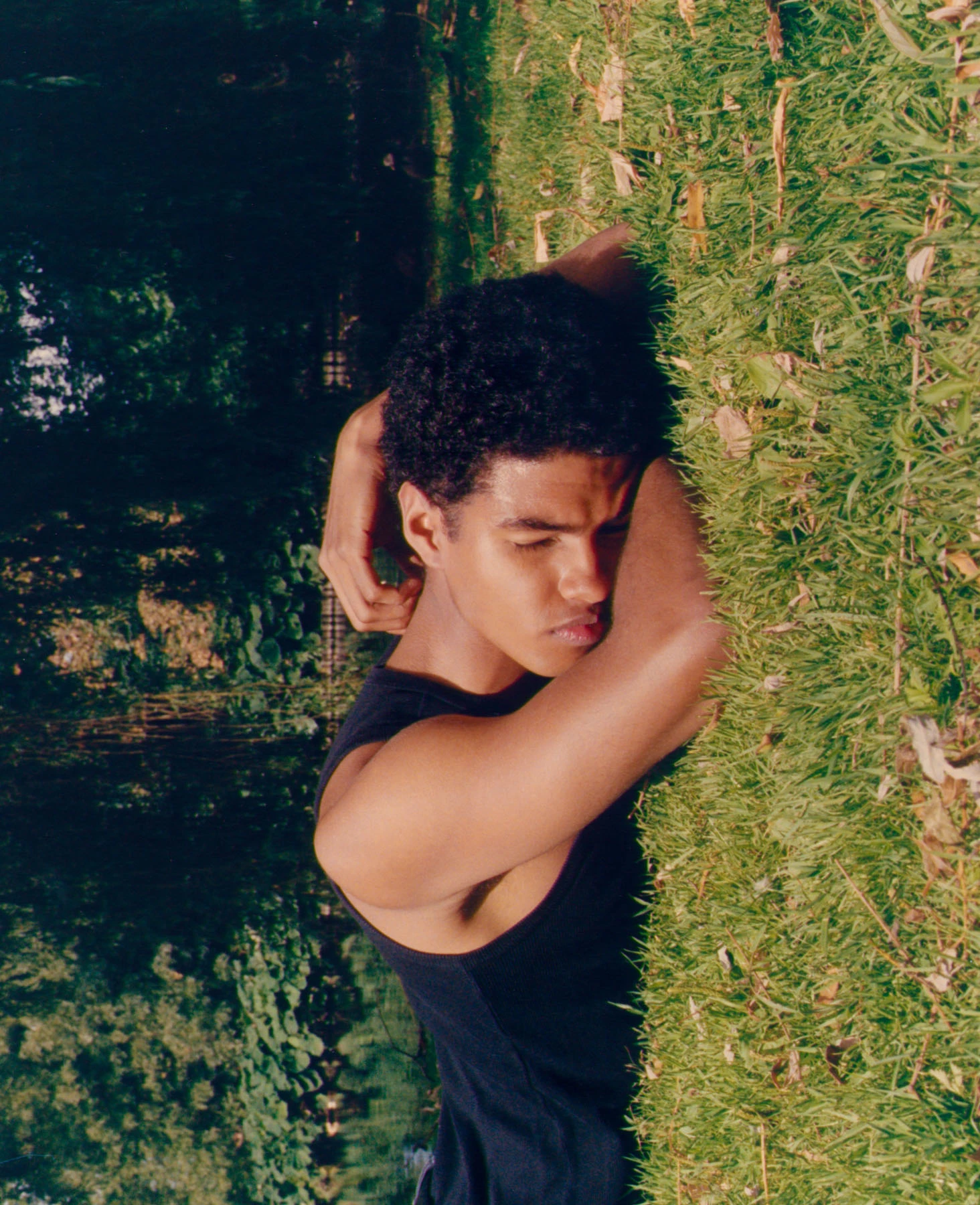 Cette photographie argentique est l’oeuvre du photographe Raul Guillermo. Cette photographie représente le portrait d’un jeune homme en débardeur noir endormi. Le mannequin est calme et paisible dormant à même le sol, dans l’herbe. La photographie a été réalisé en extérieur grace à la technique photographique de l’argentique. Les couleurs sont fortes, en contraste avec le calme et la quiétude du mannequin.